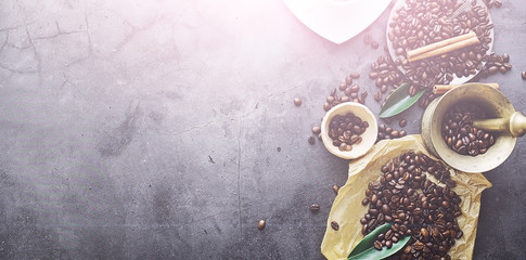 Coffee beans with green leaves for cooking. Bag of coffee. Coffee beans roasted on the table.