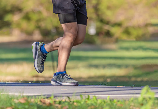 A man and a  woman are jogging in the evening on the public park