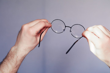The concept of poor vision. Hold a contact lens and glasses in hand. A poster for advertising...