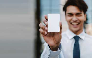 Business Card Mockup Image. Happy Young Businessman Presenting a White Blank Paper Card with...