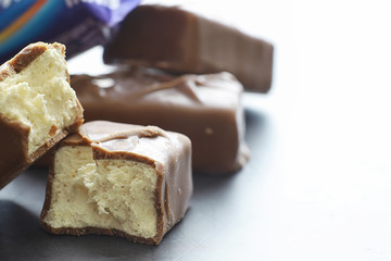 Chocolate bars on a black background in backlight. Chocolate with filling. Sweet sweets for snack...