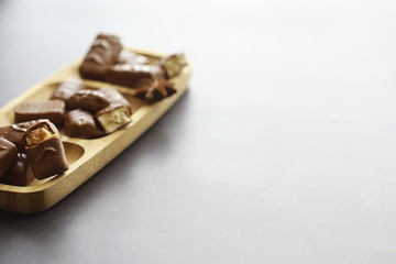 Chocolate bars on a black background in backlight. Chocolate with filling. Sweet sweets for snack and tea.