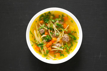 Homemade Sopa a La Minuta in a white bowl on a black background, top view. Close-up.
