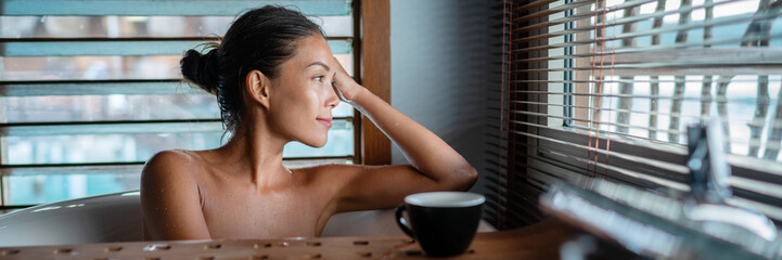 Luxury bath Asian woman relaxing in warm water enjoying view from bathroom window lying in bathtub banner panorama.