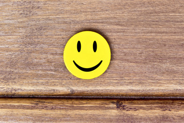 Positive Funny smiley face on a wooden background. Copy space for advertising and texts