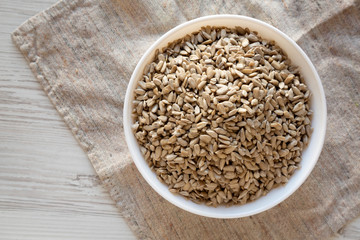 Raw Organic Sunflower Seed Kernels in a white bowl, overhead view. Flat lay, top view, from above.