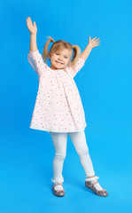 Portrait of cute little girl on blue background