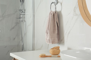 Soft towel on wall above bathroom countertop with toiletries