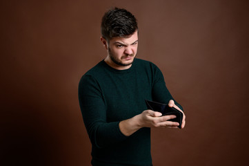 Man with brown hair showing the empty wallet