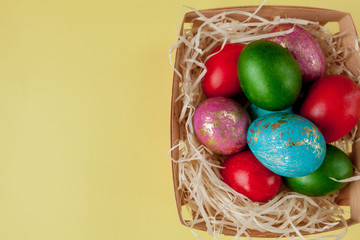 Happy Easter eggs yellow background. Golden shine decorated eggs in basket, for greeting card, promotion, poster. Copy space