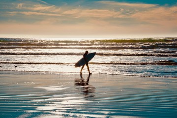 Fototapeta na wymiar Surfers on the wooden pier of Pismo Beach in California