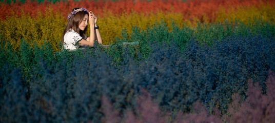 Naklejka na ściany i meble Asian woman posing and holding flower in the morning at colorful flowers field.