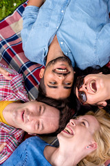 Top view of young cheerful smiling people having fun together in park