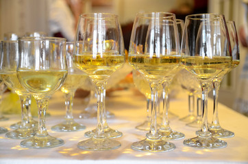 Glasses of white wine stand on a buffet table