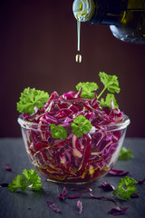 red cabbage salad and pouring olive oil in a glass bowl