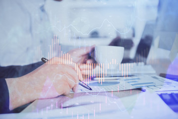 Double exposure hands with stock market chart.