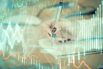 Multi exposure of hands making notes with forex chart huds. Stock market concept.