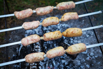 Delicious sausages on a skewer. Rest, friends, outdoors.