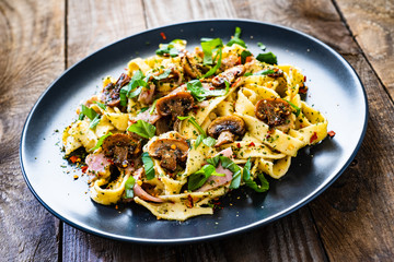 Tagliatelle with ham and chmpignon wooden table