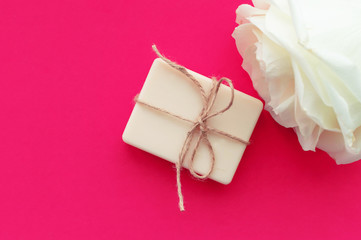the soap is tied with a rope and a white rose on a pink background with a place for the inscription. Concept of hygiene and Spa procedures.