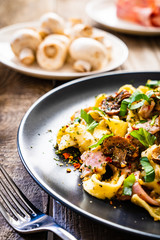 Tagliatelle with ham and chmpignon wooden table