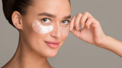 Remove wrinkles. Girl applying collagen under eye patches