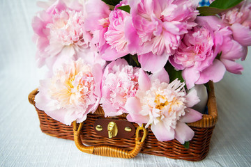 The beauty of a pink peonies bouquet in a vintage authentic brown suitcase.