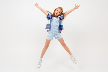 Fototapeta na wymiar Cheerful teenager girl in stylish clothes dances and enjoy of her life
