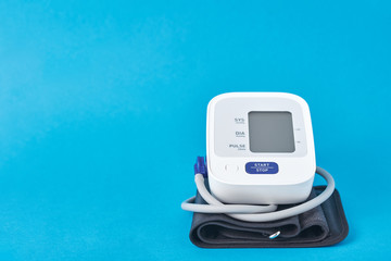 Digital blood pressure monitor on a blue background, closeup. Helathcare and medicine concept