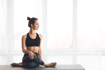 Slim girl practicing yoga looking at free space