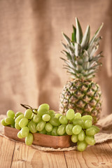 green grapes and pineapple on a wooden board