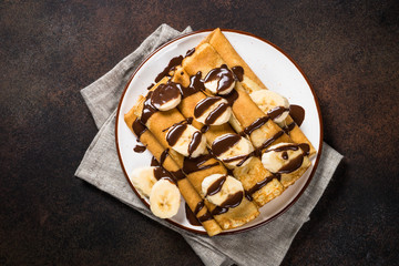 Crepes with chocolate and banana top view.