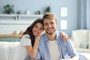 Portrait of cute young couple sitting in sofa.