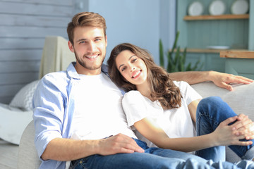 Fototapeta premium Portrait of cute young couple sitting in sofa.