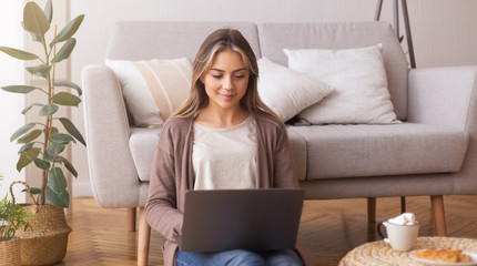 Young woman browsing on laptop at home