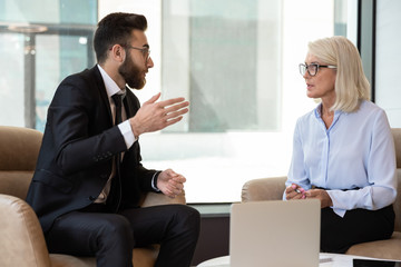 Middle eastern ethnicity businessman european businesswoman discuss deal in office