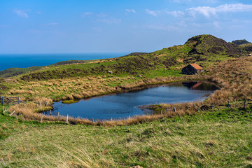 Red cabin on a lake and ocean