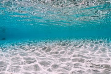 Turquoise ocean water with sandy bottom underwater. © artifirsov