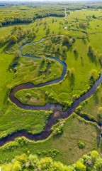 Forest in summer colors. Green deciduous trees and winding blue river in sunset. Soomaa wooded meadow, Estonia, Europe