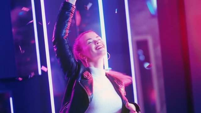 Neon girl. Night party. Happy young woman enjoying dancing in confetti rain purple illumination.