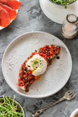 Sandwich with red fish, poached egg, balsamic vinegar and micro-greens