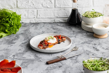 Sandwich with red fish, poached egg, balsamic vinegar and micro-greens