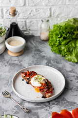 Sandwich with red fish, poached egg, balsamic vinegar and micro-greens