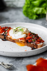 Sandwich with red fish, poached egg, balsamic vinegar and micro-greens