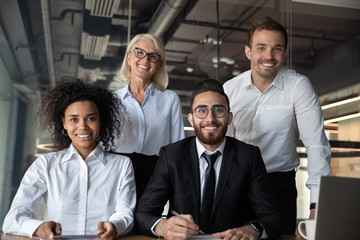 Portrait of pretty successful multi-ethnic corporate close-knit team