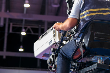 operator behind the video camera shoots sports competition, professional equipment for broadcasting...