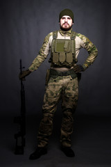 Fototapeta premium A soldier in camouflage clothing poses in a Studio