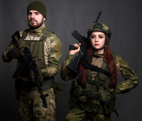 Twol soldiers in camouflage clothing poses in a Studio