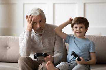 Different generations family playing video game together in living room.