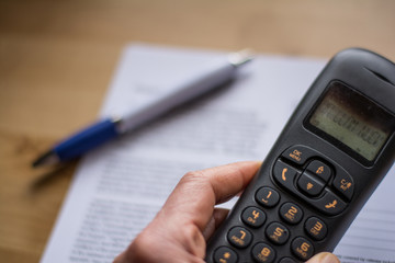 To make a phone call. Ink pen on a contract